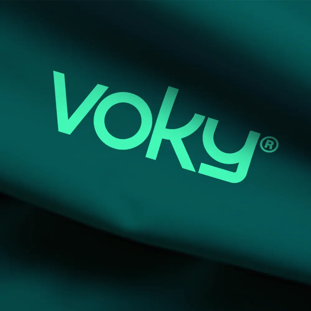 Voky-logga tryckt p&aring; m&ouml;rkgr&ouml;n textil